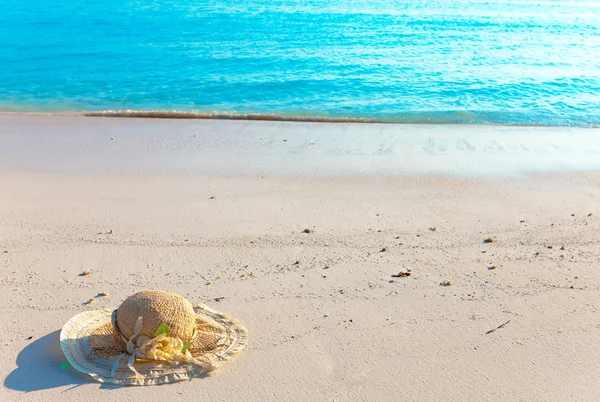 Hasır şapka kum üzerine deniz kenarında yattı. — Stok fotoğraf