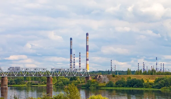 El puente ferroviario a través del río y las tuberías de fábrica —  Fotos de Stock