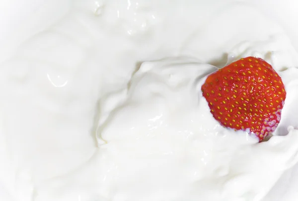 Jordgubbar som faller i mjölk — Stockfoto