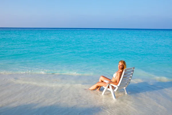 Junge hübsche Frau bräunt sich im Strandkorb, es steckt im Ozean — Stockfoto