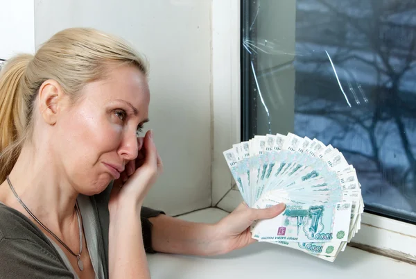 Weint die Hausfrau und zählt Geld für die Reparatur eines doppelt verglasten Fensters. — Stockfoto