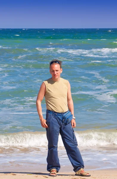 L'uomo sportivo in piedi vicino al mare — Foto Stock