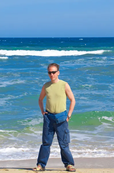L'uomo sportivo in piedi vicino al mare — Foto Stock