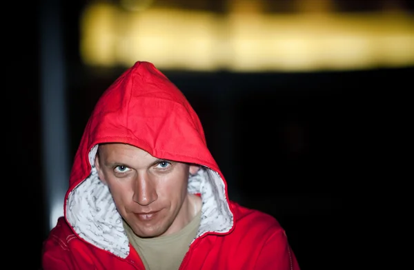 Retrato nocturno del joven elegante con chaqueta roja y capucha — Foto de Stock