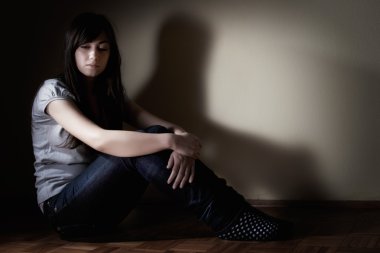 katta oturan depresif genç kız.