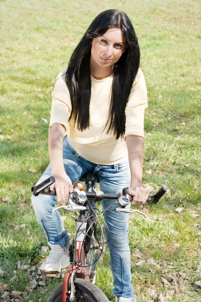 Mladá žena na kole venku — Stock fotografie
