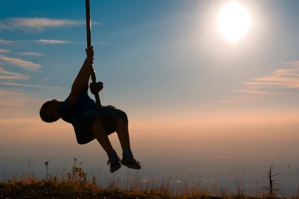 Silhouette of a boy playing with a tyrolean traverse — Stock Photo, Image