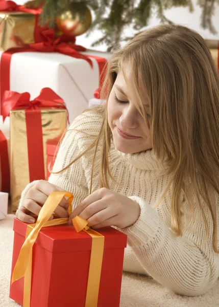 Meisje met een kerst hoed en een cadeautje — Stockfoto
