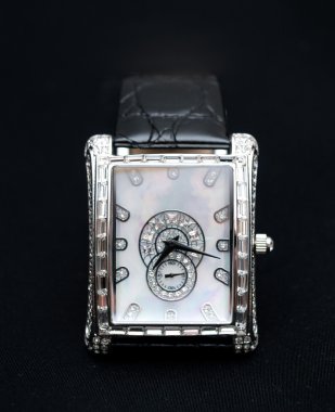 Silver women's watch on a dark background clipart