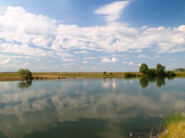 pastoral manzara nehir arazi, mavi gökyüzü ve bulutlar yansıması ile