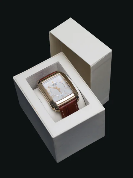 暗い青色の背景にあるボックス内の金の腕時計 — ストック写真