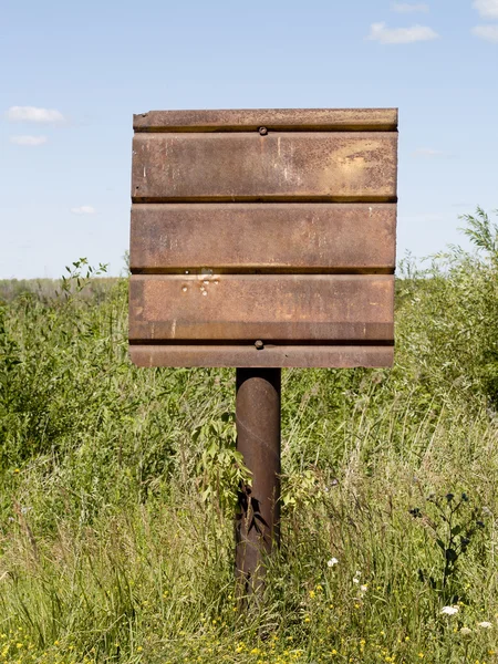 Roestige Uithangbord Een Pijler Omgeven Door Groen Gras — Stockfoto