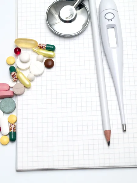Multi Gekleurde Tabletten Een Thermometer Stethoscoop Een Potlood Kladblok — Stockfoto