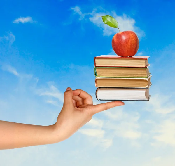 Livres avec pomme à la main comme un don de l'éducation — Photo