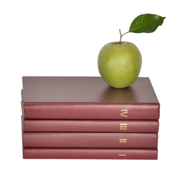 Zelené jablko na hromadě knih na bílém pozadí — Stock fotografie