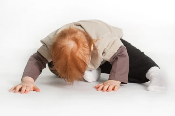 Criança deitado no chão branco — Fotografia de Stock
