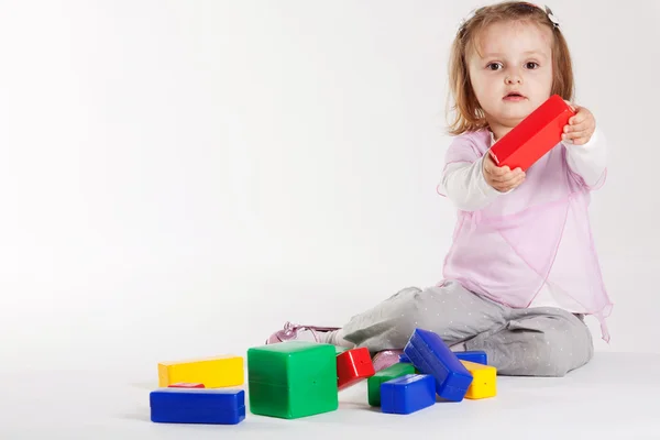 Little girl plays with cubes — Stock Photo, Image