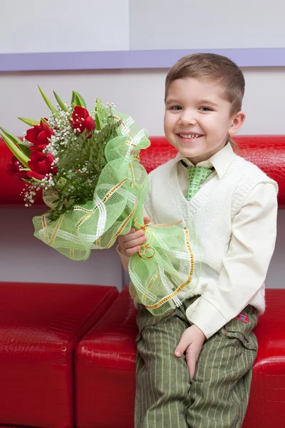 Kleiner Lustiger Junge Mit Blumen Auf Der Couch — Stockfoto