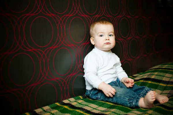 Mały Chłopiec Poważne Siedzący Obok Ścianie Domu — Zdjęcie stockowe