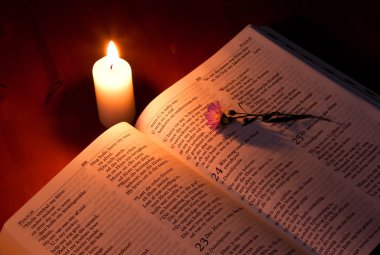 Bible by candle light clipart