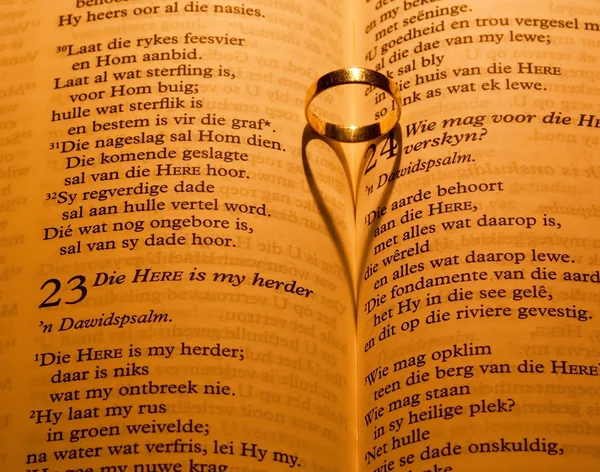 Ring on bible with heart shadow — Stock Photo, Image