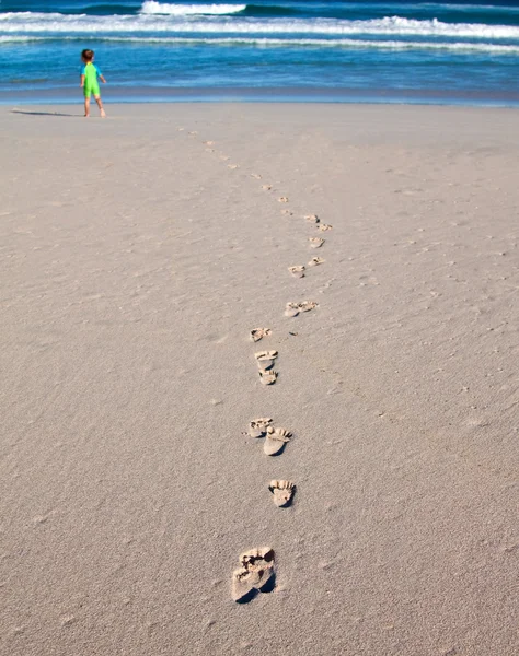 stock image Footprints of a child on the beach going towards the breakers