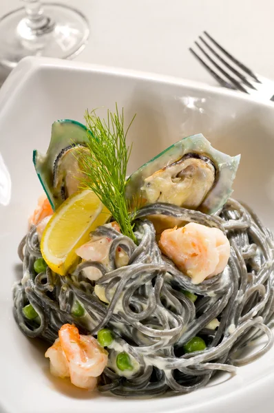 stock image Fresh seafood black squid ink coulored spaghetti pasta tipycal italian food