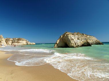 A section of the idyllic Praia de Rocha beach clipart