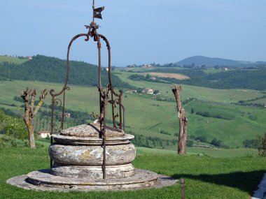 Old well on the background of the Tuscan landscape clipart