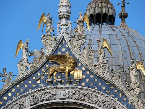 Venice - Lion of St. Mark's surrounded by angels on the facade of the — Stock Photo, Image