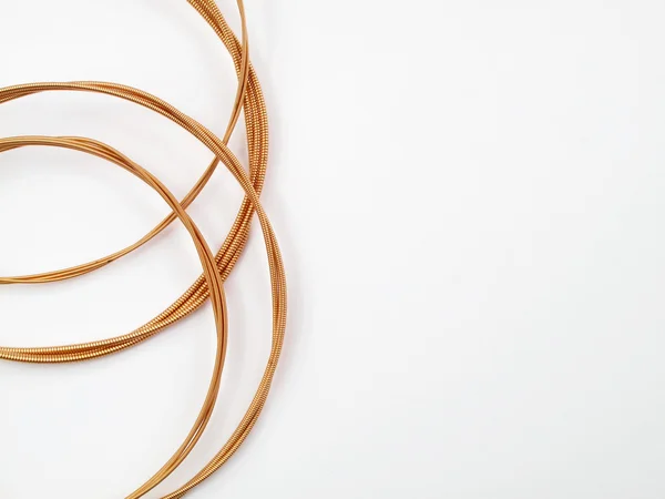 stock image Coiled acoustic guitar strings on white background