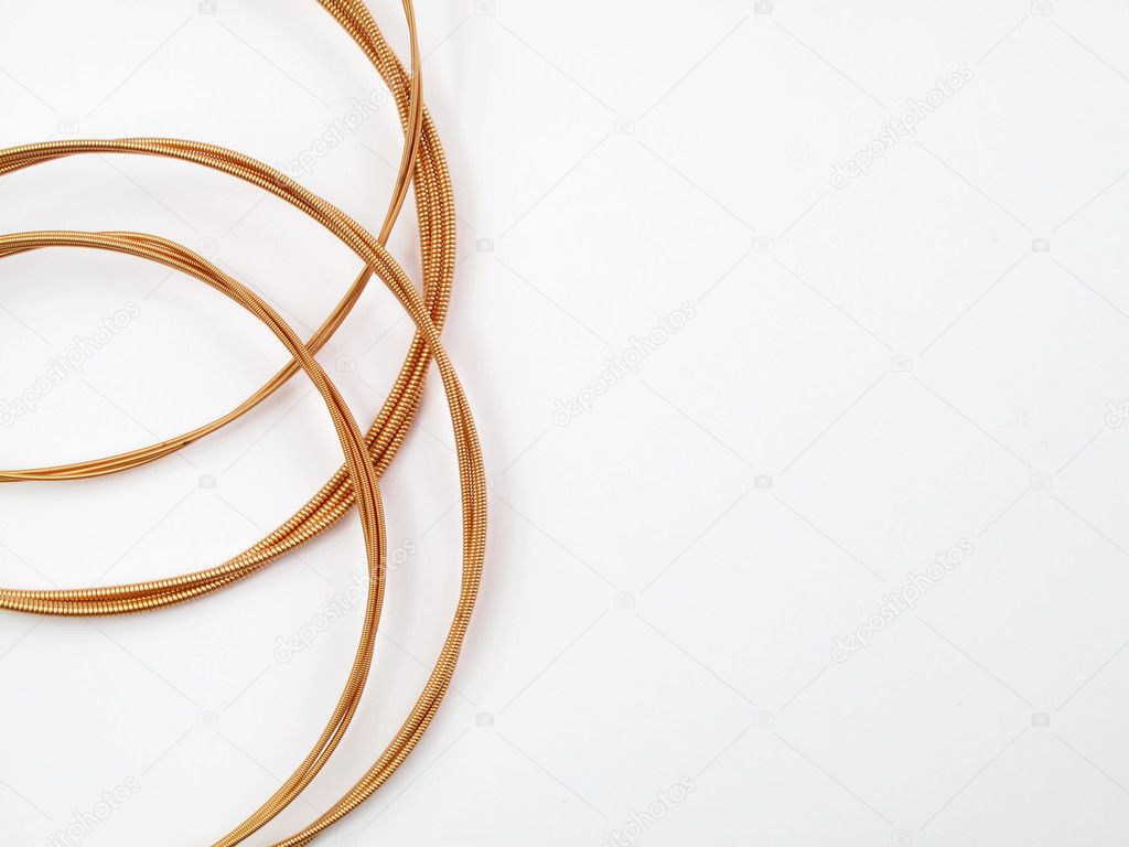 Coiled acoustic guitar strings on white background