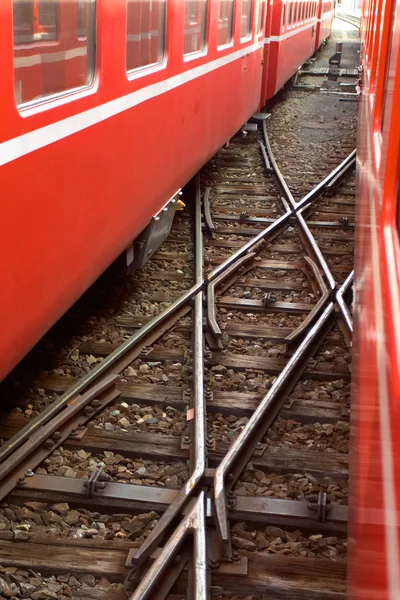 Железнодорожный Переход Между Двумя Красными Швейцарскими Поездами — стоковое фото