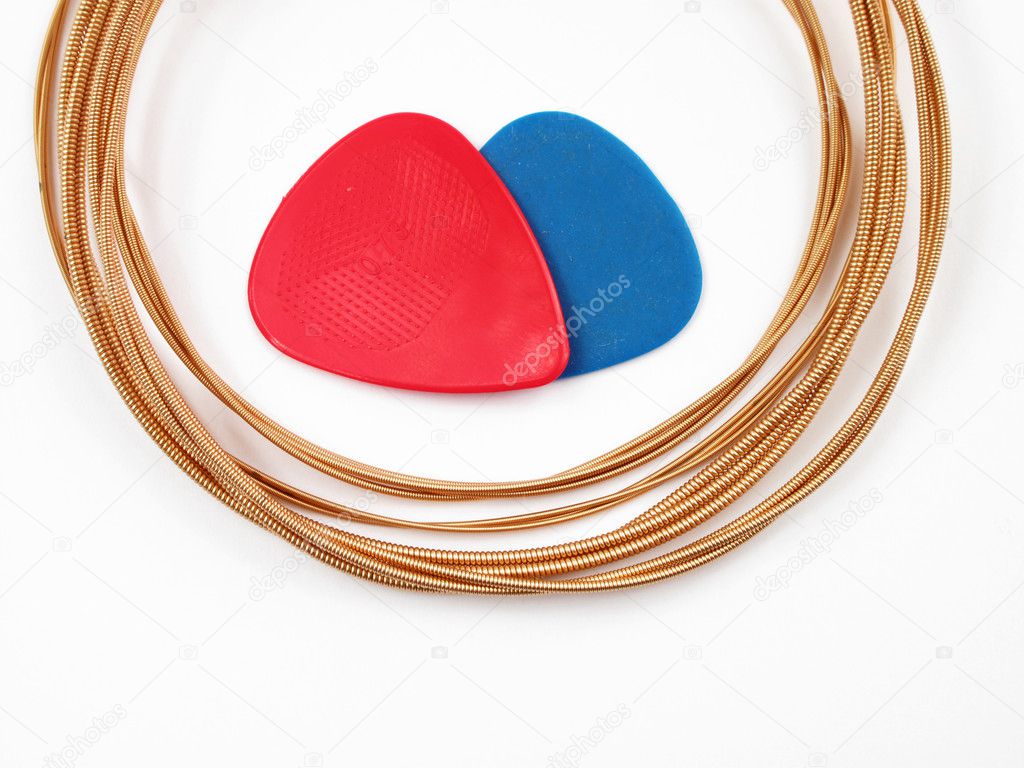 Acoustic guitar strings and plectrums on white background