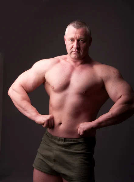 Bodybuilder Poseren Grijze Achtergrond — Stockfoto