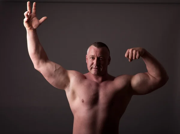 Bodybuilder Poserar Grå Bakgrund — Stockfoto