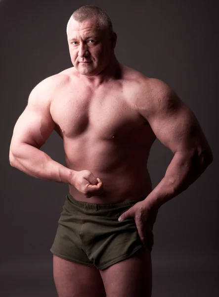 Bodybuilder Posiert Vor Grauem Hintergrund — Stockfoto