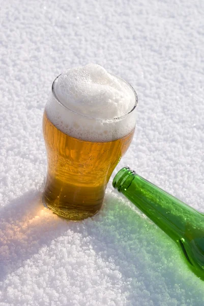 雪の上のガラスと緑のボトルのビール — ストック写真