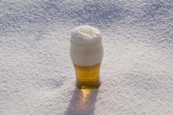 在玻璃中大啤酒站立在雪上 — 图库照片
