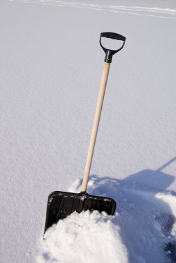 Snow shovel on on piled hill snow clipart