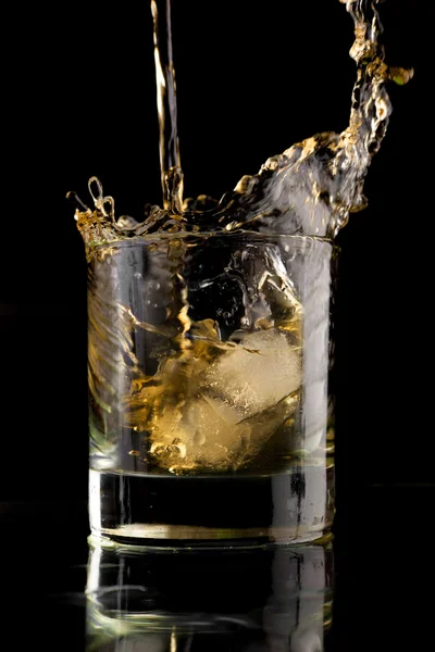 黑色背景的威士忌杯威士忌洒在杯子里 威士忌加冰块 — 图库照片