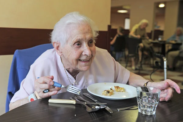 高级女子微笑着和吃的退休基金 — 图库照片