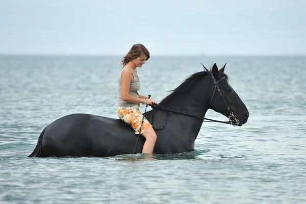 美丽的黑色马在海和美丽的女人 — 图库照片