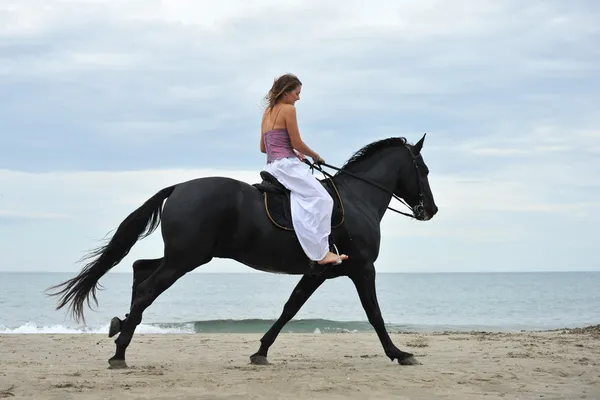 Mulher e cavalo na praia — Fotografia de Stock