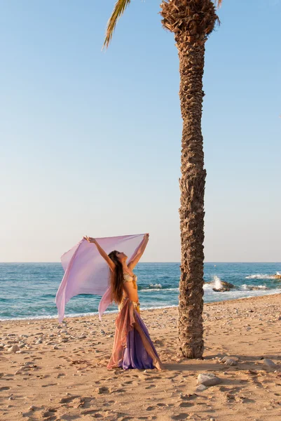 Східна танцівниця виступає на пляжі — стокове фото