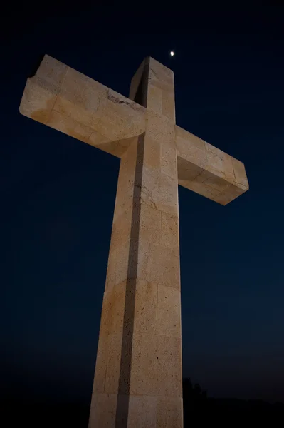 巨大な石造りの十字の夕方の空に対して記念碑 — ストック写真