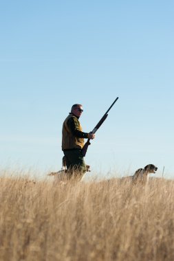 A hunter and his dog, a strong parntership clipart