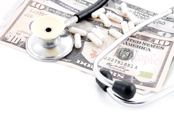 Stetoskop och några piller på dollar — Stockfoto