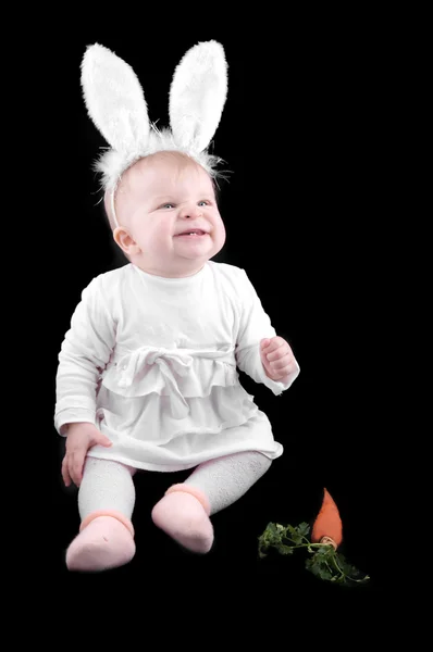 Funny baby in bunny costume and carrot — Stock Photo, Image