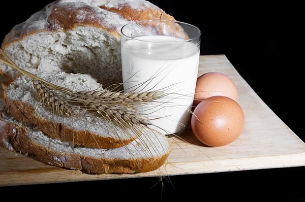 Glass of milk, wheat, eggs and bread — Stock Photo, Image